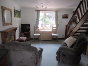 a living room with a couch and a television at Hops Annex in Brockenhurst