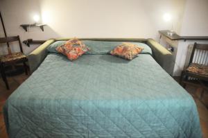 a green bed with two pillows on top of it at Dorsoduro - Corte della Comare in Venice
