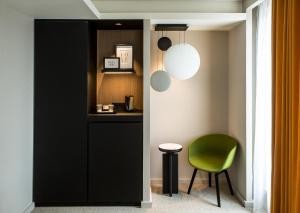 a living room with a chair and a table at Mercure Paris 17 Batignolles in Paris