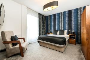 1 dormitorio con 1 cama y 1 silla en The Ainscow Hotel, en Mánchester