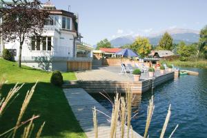 a house with a dock next to a body of water at Villa Cattina in Seeboden