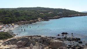 a group of people in the water at a beach at Casa vacanze Piscinas in Piscinas