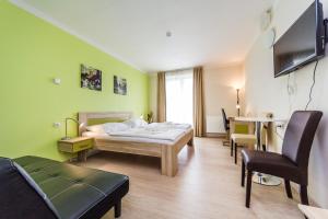 a room with a bed and a table and chairs at Nad Královnou Hotel & Restaurant in Prague