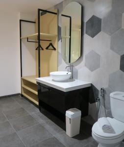 a bathroom with a sink and a toilet and a mirror at Nomaden Urban Stay in Semarang