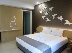 1 dormitorio con 1 cama con pájaros en la pared en Nomaden Urban Stay en Semarang