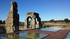 an outdoor deck with an old building and an arch at Puerta Trujillo in Plasencia