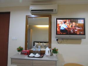 um quarto com uma televisão numa parede com uma mesa em Safari Hotel em Kuala Lumpur