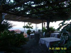 a patio with tables and chairs under a pergola at Locanda Degli Agrumi in Conca dei Marini