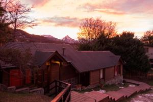 a wooden cabin with mountains in the background at Aves del Sur in Ushuaia