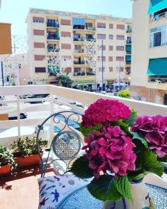 um vaso cheio de flores roxas sentado numa mesa em Hotel La Bussola em Anzio