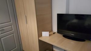 uma televisão sentada numa mesa ao lado de uma porta em Park Rooms em Dugo Selo