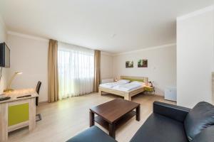 a living room with a couch and a bed at Nad Královnou Hotel & Restaurant in Prague