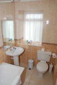 a bathroom with a toilet, sink and tub at Pontac House Hotel in St Clements