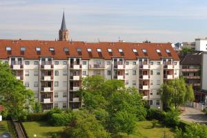 a large white apartment building with a red roof at acora Karlsruhe Zentrum Living the City in Karlsruhe