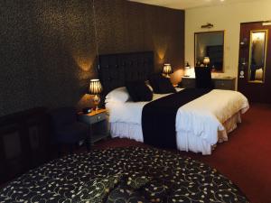 a hotel room with two beds and a mirror at Best Western Compass Inn in Tormarton
