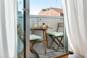 バルセロナにあるGlasir Apartments Barcelonaのバルコニー(テーブル、椅子付)