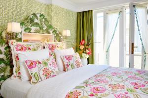 a bedroom with a large bed with floral pillows at Hotel Estheréa in Amsterdam
