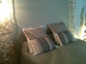 two pillows on a bed in a bedroom at Chambres d'Hôtes La Rose des Vents in Ginestas