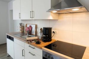 a kitchen with white cabinets and a sink and a stove at Parkblick Appartement - Entspannung pur! in Ober-Hambach +14 photos