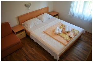 a bedroom with a bed with two towels on it at Apartments Sara in Lopar