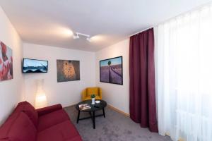 sala de estar con sofá rojo y mesa en Bergblick Appartement, en Ober-Hambach