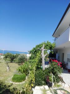 a garden in front of a house with a tree at Apartment Marijan - Rtina in Rtina