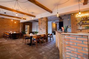 a restaurant with tables and chairs and a brick wall at Gościniec Ceglane Kąty in Dwikozy