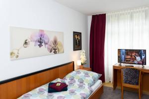 Schlafzimmer mit einem Bett, einem Schreibtisch und einem Fenster in der Unterkunft Schönblick - gemütlich übernachten! in Ober-Hambach