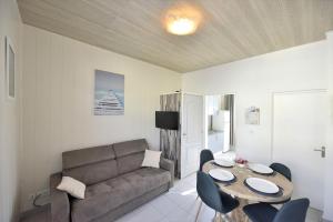 sala de estar con sofá, mesa y sillas en Appartement "Mer" - 50m Front de Mer, en Berck-sur-Mer