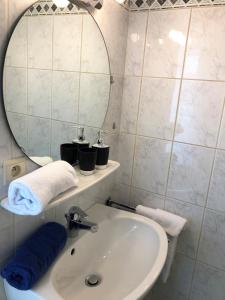 a white bathroom with a sink and a mirror at Au Petit H in Stavelot +12 photos