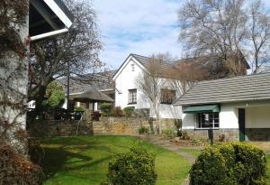 a white house with a yard with a yard at Himeville Arms in Himeville