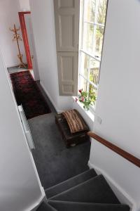 a hallway with a staircase with a bench and a window at John McDouall Stuart View in Dysart