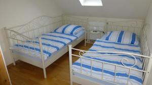Camera con 2 letti e cuscini a righe blu e bianche. di Ferienwohnung Dangast a Varel