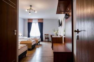 Dwikozy的住宿－Gościniec Ceglane Kąty，酒店客房设有两张床和一张桌子。