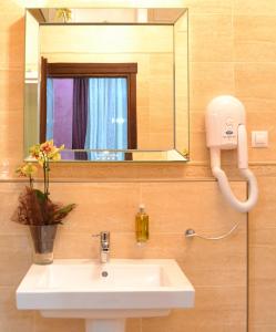 uma casa de banho com um lavatório e um espelho em Daily Plaza Hotel em Suceava