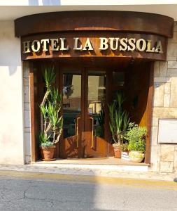 um hotel la bussola com vasos de plantas na porta em Hotel La Bussola em Anzio