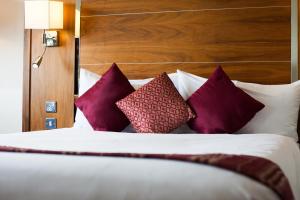 a bedroom with a bed with purple and white pillows at Waterfront Southport Hotel in Southport