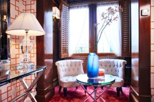 a room with two chairs and a table with a blue vase on it at Hotel Estheréa in Amsterdam