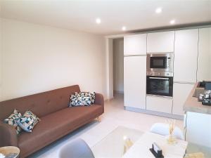 a living room with a couch and a kitchen at MINZONI94 - TwoBedroom+Garden in Lido di Camaiore
