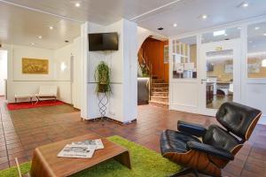 a living room with a table and a chair at Hotel Atlanta in Hannover