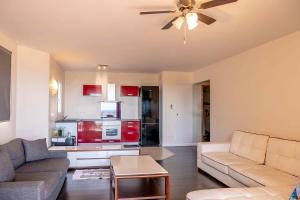 a living room with a couch and a ceiling fan at Teva's Apt in Punaauia