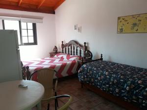 a bedroom with two beds and a table and a table at Lomas de Belgrano in Villa General Belgrano +63 photos