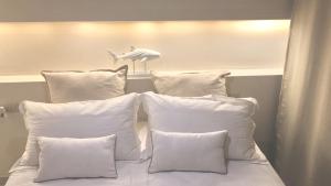 a bed with white pillows and a white headboard at MINZONI94 - TwoBedroom+Garden in Lido di Camaiore
