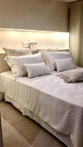 a large white bed with white pillows on it at MINZONI94 - TwoBedroom+Garden in Lido di Camaiore