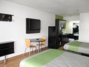 Habitación de hotel con cama y mesa con sillas en Motel 6-Alexandria, LA - South en Alexandria