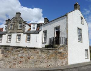 a man standing in the window of a white building at John McDouall Stuart View in Dysart