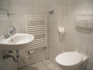 a white bathroom with a toilet and a sink at Freiraum Hostel Kreuzberg in Berlin