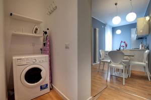 a kitchen and dining room with a washing machine in a room at Botteri Palace Apartments in Venice