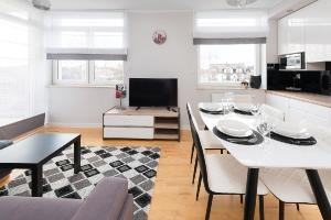 a living room with a white table and chairs at Apartamenty Apartinfo Fregata in Jastrzębia Góra