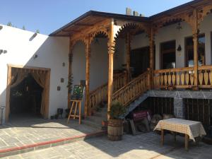Machanents Guest House في Vagharshapat: منزل به شرفة خشبية ودرج